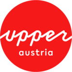 Logo Górna Austria Turystyka: czerwone kółko z białym napisem upperaustria